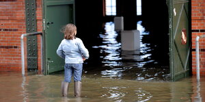 Ein Mädchen schaut in die überflutete Fischauktionshalle.