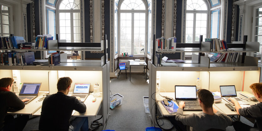 Studenten am Computer in einer feudalen Bibliothek