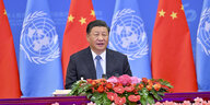Der chinesische Präsident Xi Jinping sitzt auf einer Rednertribüne