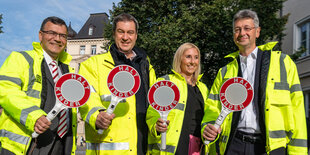 Florian Herrmann, Markus Söder, Anna Stolz und Michael Piazolo posieren in Schülerlotsten-Montur für die Kamera.