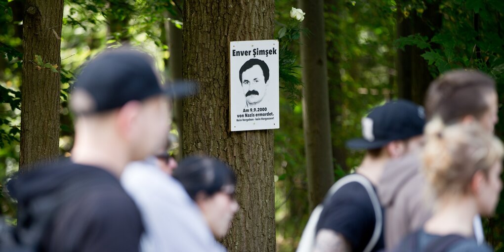 Ein Bild des Mordopfers Enver Simsek hängt an einem Baum am Tatort