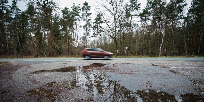 Ein Auto fährt an einer Parkbucht an einer Straße in Nürnberg vorbei