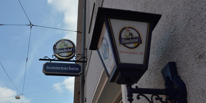 Das Schild der Bar "Sonnenschein" und eine Laterne