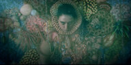 Das Gesicht einer Frau blickt aus einer Wand unter Wasser, die mit Korallen und Muscheln bewachsen ist und in er sie selbst zu verschwinden scheint