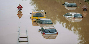 In einer unter Wasser stehenden Straße sind nur noch die Autodächer zu sehen.