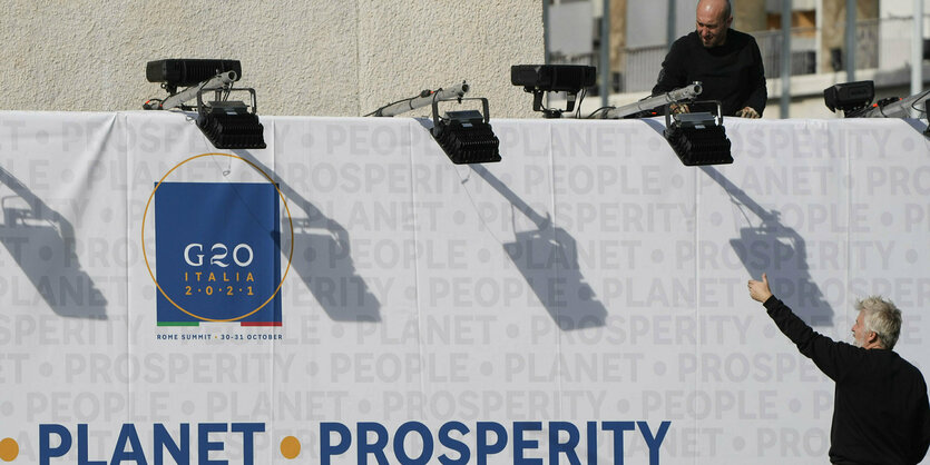 Mann vor Plakat mit der Aufschrift "Planet" und "Prosperty"