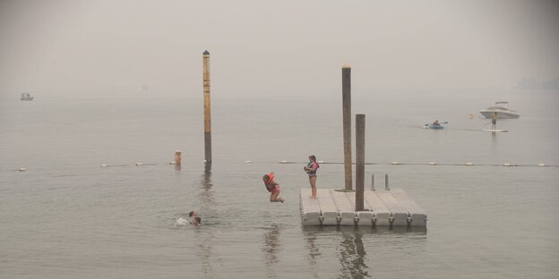 Kinder springen von einer schwimmenden Plattform ins Wasser
