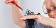 Eine Friseurin schneidet Haare.