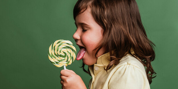 Ein Kind lutscht an einer Süßigkeit.