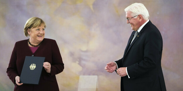Steinmeier und Merkel mit Entlassungsurkunde, Merkel lacht