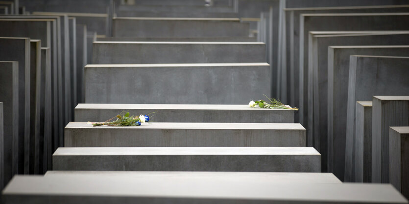 Auf dem Holocaust Mahnmal von Berlin sind weiße Rosen abgelegt.