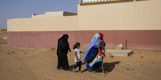 Sahrauische Geflüchtete laufen entlang eines Gebäudes im Daijla-Flüchtlingslager in Algerien