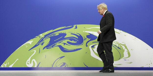 Boris Johnson vor dme Logo der Konferenz, eine Erdkugel