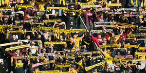 Dynamo Dresden Fans heben gelben Schals hoch