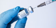 Mit einer Spritze wird Impfstoff aus einem Fläschen aufgezogen