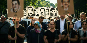 Demonstrierende halten Schilder mit Portraits in die Höhe