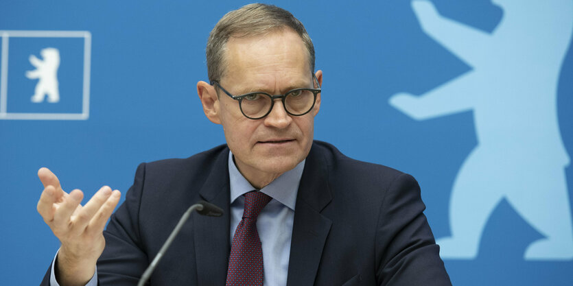 Michael Müller gestikutliert auf einer Pressekonferenz