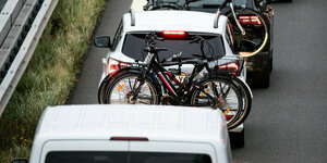 Fahrräder, die am Kofferraum eines Autos befestigt sind, Autos stehen im Stau
