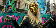 Klimaaktivistin mit goldener Maske demonstriert