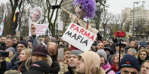 Demonstranten mit einem Schild, auf dem "Farma Mafia" steht