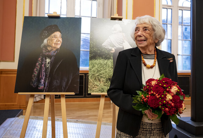 Margot Friedländer steht neben einem Porträt von ihr selbst