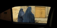 Zwei Frauen in Burkas in Kabul, gesehen aus einem Autofenster
