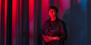 SPD-Vorsitzende Saskia Esken vor einem Vorhang im roten Licht.