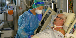 Eine Ärztin kümmert sich um einen Patienten auf der Intensivstation