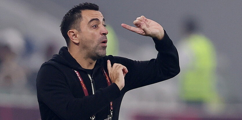 Xavi steht am Spielfeldrand und macht eine expressive Geste mit seinen Händen