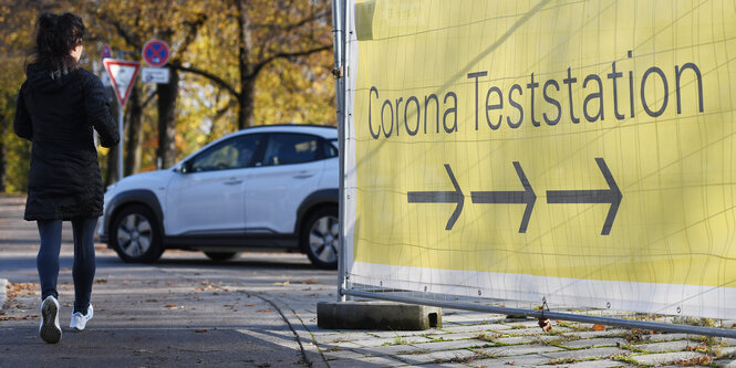 Eine Frau läuft an einem Schnelltest-Banner vorbei