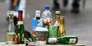 leere Alkoholflaschen stehen draussen auf einer Mauer