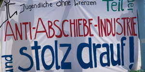 Das Bild zeigt ein Demoplakat, auf dem geschrieben steht: "Teil der Anti-Abschiebe-Industrie und stolz darauf!"