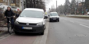 Ein weißer Lieferwagen steht auf einem Radweg