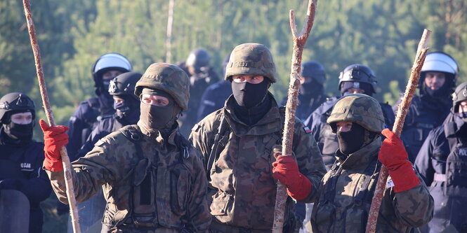 Soldaten mit Stöcken bewaffnet gestikulieren.