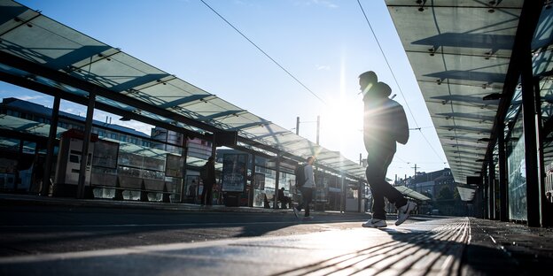 Ein einzelner Mann läuft über die leere Bushaltestelle am Bremer Hauptbahnhof.
