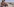 Ein Mann und eine Frau in Badekleidung beobachten am Strand von Gran Canaria ein Gruppe von Migranten