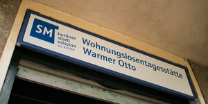 Auf einem Schild stehen die Worte "Wohnungslosentagesstätte Warmer Otto" und "Berliner Stadtmission" geschrieben