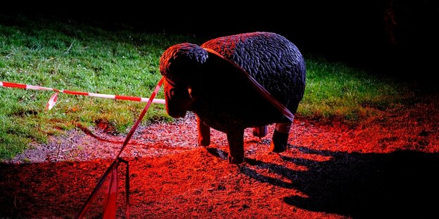 Die Skulptur eines Schafs auf einem Spielplatz bei Nacht ist mit einem Absperrband versehen