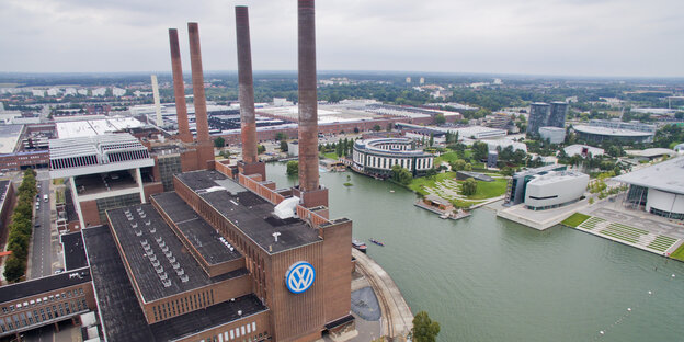 Luftaufnahme des VW-Werkes in Wolfsburg mit den charakteristischen Türmen des Heizkraftwerkes und der Autostadt im Hintergrund