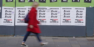 Frau läuft an Plakaten vorbei, auf denen "Blah b lah" steht