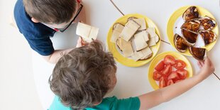 Kinder mit Tellern voller Essen von oben