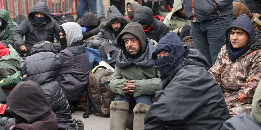 Männer kauern an einem Grenzübergang