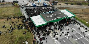 Dronenaufnahme: Eine schwarze Menschenmenge an einer Grenzstation