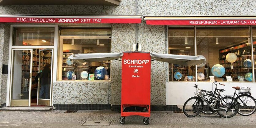 Vor einer Buchhandlung steht ein Buchwagon mit der Aufschrift "Schropp"