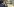 Kurz, seitlich von oben fotografiert, sitzt an seinem Platz, hält die Hand am Kinn und schaut nachdenklich