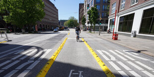 Radfahrer zwischen Busspuren, geschützt durch gelbe Längsschwellen