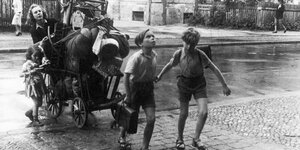 Szene aus "Die Kuckucks": Kinder ziehen einen Bollerwagen