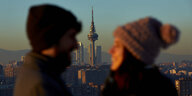 Ein Paar vor der Skyline von Madrid mit einem Fernsehturm.