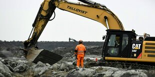 Bauarbeiter und bagger auf einer Baustelle