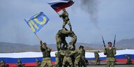 Eine russische Fahne wird geschwungen auf einer Pyramide, die Soldaten bilden
